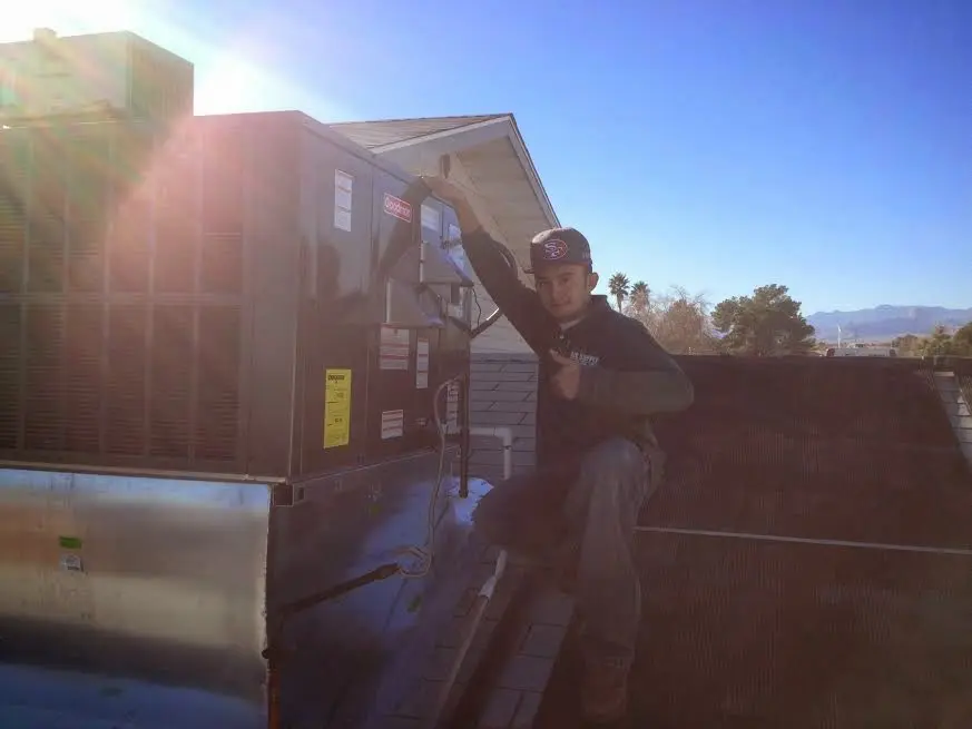 HVAC technician performing HVAC Inspection on a rooftop unit in Elmira